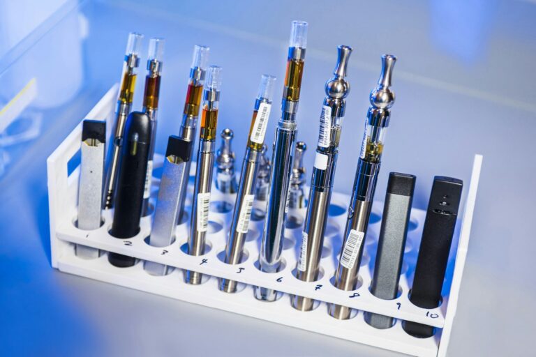 Multiple cannabis vape cartridges in a lab test rack, showcasing different models and oil levels