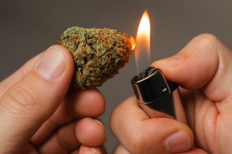 Person lighting a cannabis bud on fire to show decarboxylation from THCA to THC.